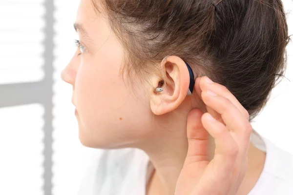 Girl assumes hearing aid. — Stock Photo, Image