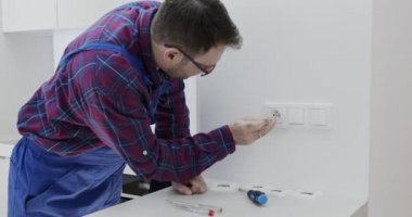 Bir kontağın tamiri, bir elektrik prizi. Bir elektrikçi kontağı tamir eder.