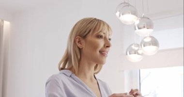 Saç fırçalamak. Kadın saçını at kuyruğu şeklinde tarıyor. Güzel genç bir kadın aynanın önünde saçını tarıyor..