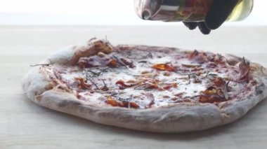 Pizzanın üzerine yağ dök. Parma jambonlu, peynirli ve biberiyeli pizza. Kıtır kıtırlı lezzetli pizza. Pizza pişirme adımları.