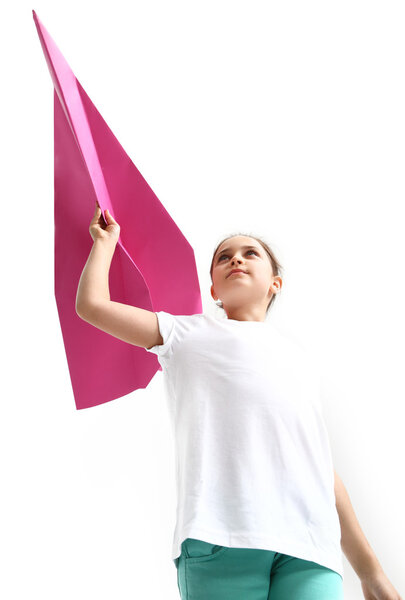 Маленькая девочка летит на бумажном самолёте
