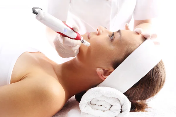 Kosmetikerin führt Nadelmesotherapie im Gesicht einer Frau durch Stockbild