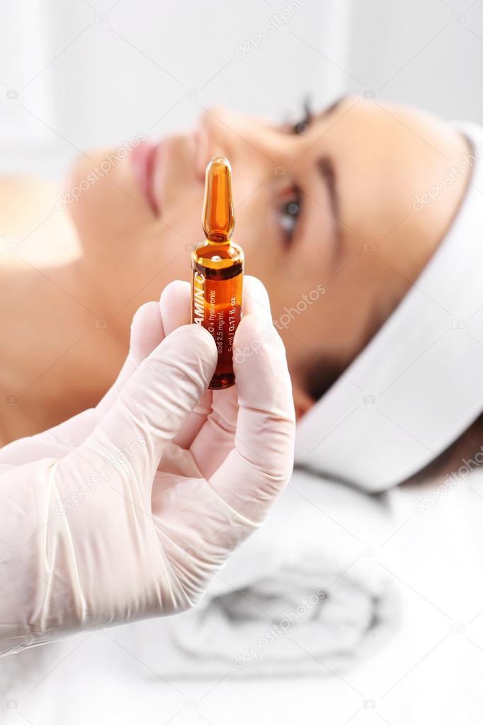 Cosmetic ampoule, a woman in the beauty salon