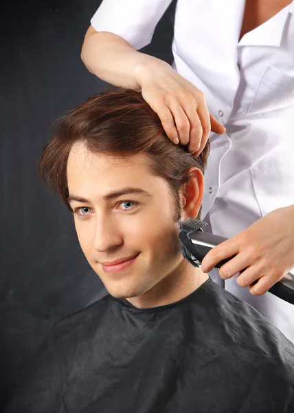 Cabeleireiro corta cabelo jovem rapaz — Fotografia de Stock