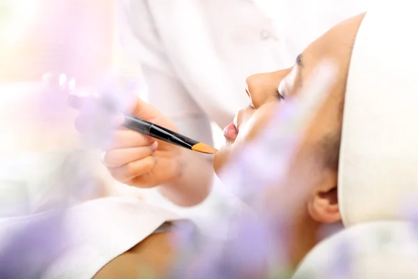 Esteticista aplicado maquillaje en la cara de una mujer — Foto de Stock