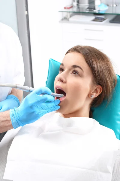 Traitement de la dent, le dentiste nettoie la perte — Photo