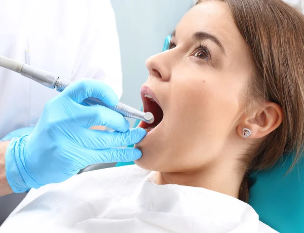 Traitement de la dent, le dentiste nettoie la perte — Photo