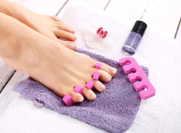 Фиолетовый педикюр, ухоженная женская нога — стоковое фото