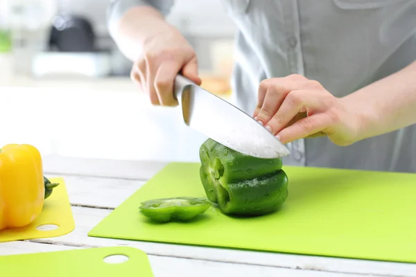 La femme coupe du poivre pour la salade — Photo