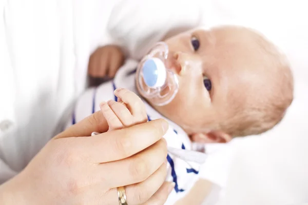 Petit homme, bébé accroché à sa mère — Photo