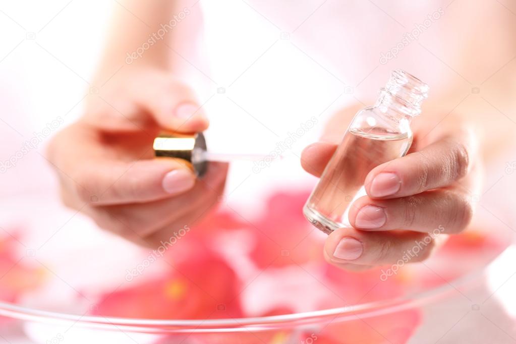 Woman paints the nails cuticle oil and nail
