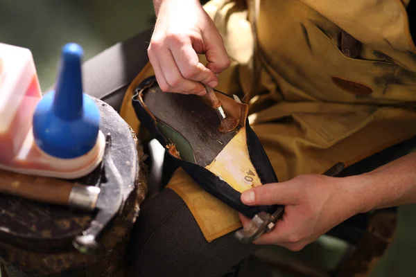 Shoemaker šije boty — Stock fotografie