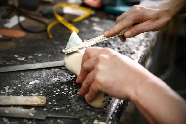 Shoemaker šije boty — Stock fotografie