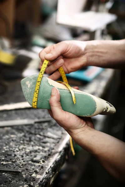 Schoenmaker naait schoenen — Stockfoto