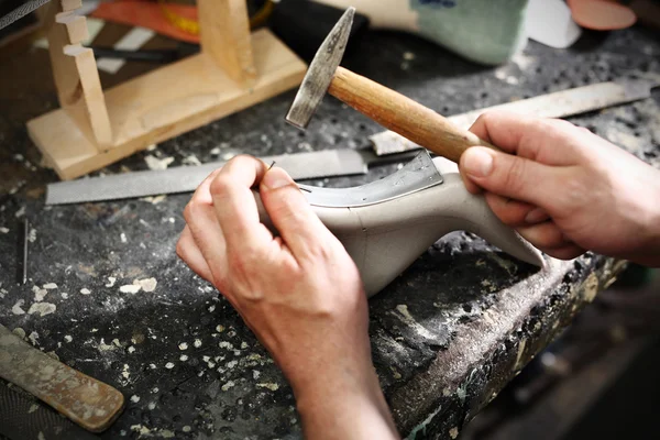 Shoemaker šije boty — Stock fotografie