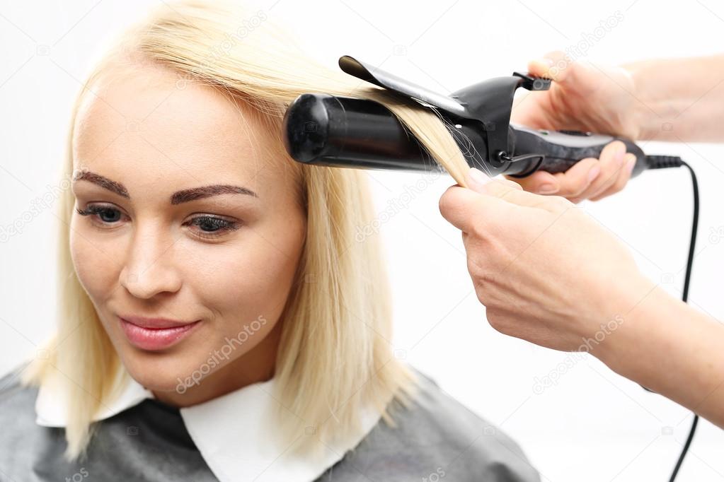 Hairdresser modeling hair curling iron