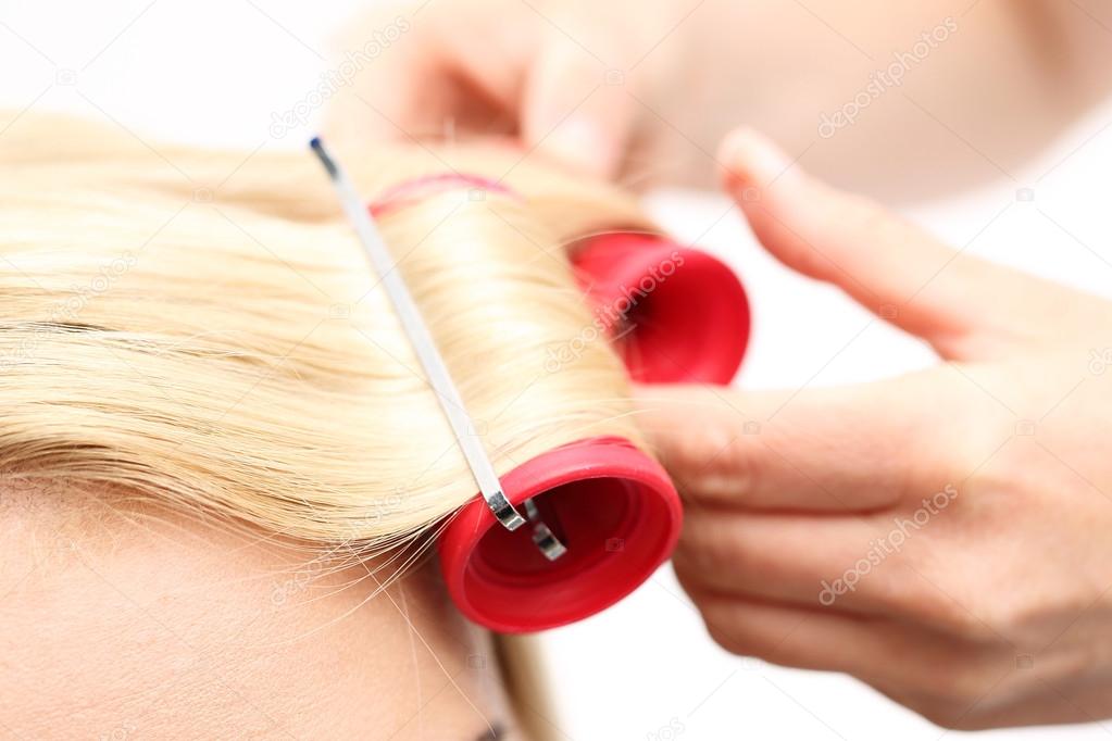 The woman at the hairdresser, twirling hair curlers