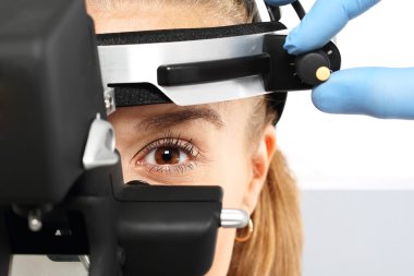 Ophthalmologist examines the eyes using a ophthalmic device clipart