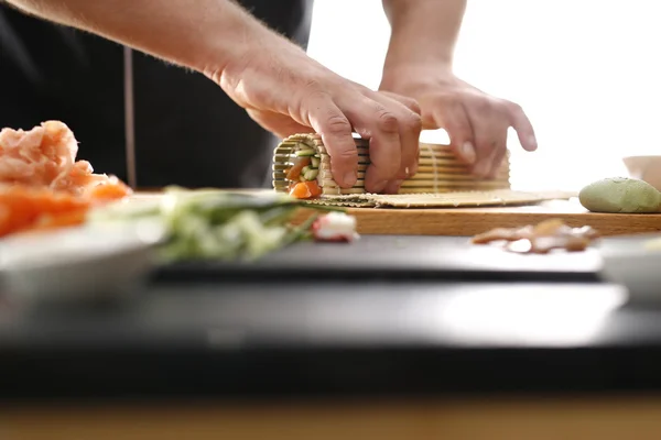 Sushi master zamienia rolki sushi — Zdjęcie stockowe