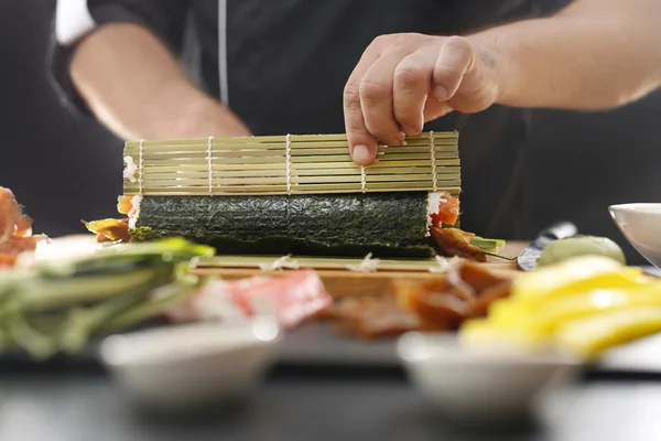 Sushi master zamienia rolki sushi — Zdjęcie stockowe