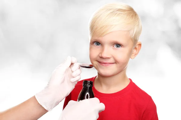 Ένα νόστιμο σιρόπι, το αγόρι πίνουν μια θεραπεία για το κοινό κρυολόγημα. — Φωτογραφία Αρχείου