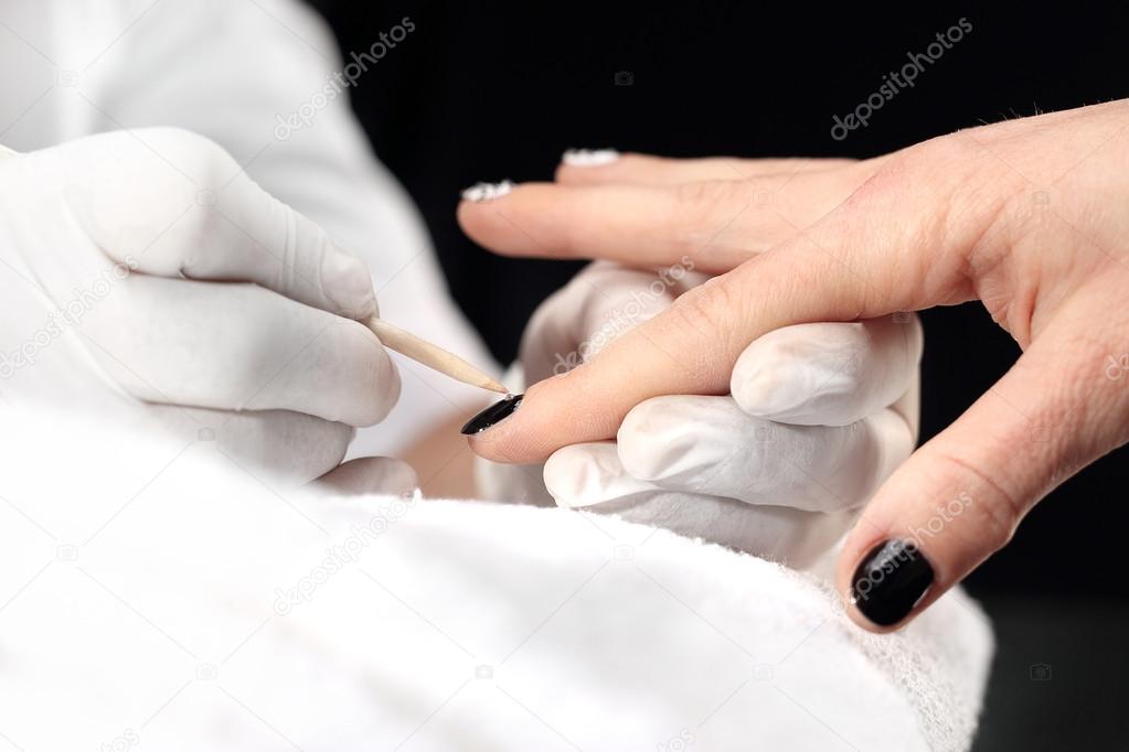 Manicure white nail polish. beautician painting nails