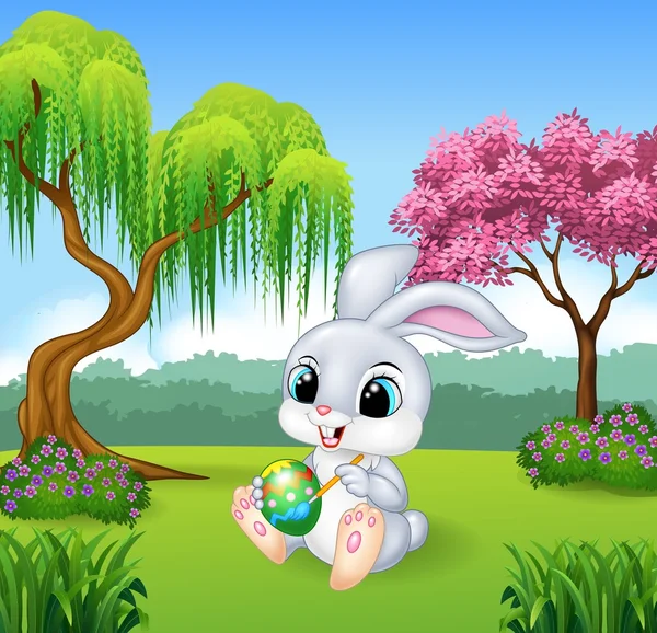 Cartoon little bunny painting an egg — Stock Vector