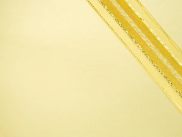 Zlatá stuha na žlutém prostoru — Stock fotografie