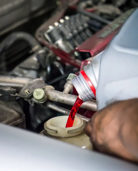 Hand pouring transmission fluid — Stockfoto