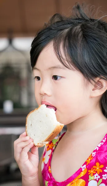 Cute little girl eating bread