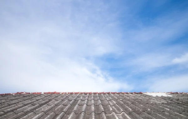 Céu nublado sobre as telhas do telhado de amianto — Fotografia de Stock