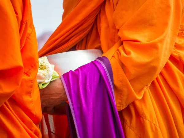 Monje budista sosteniendo cuenco de limosna y flor de loto — Foto de Stock
