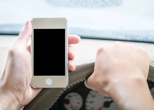 Driver holding smartphone in the car — Stock Photo, Image