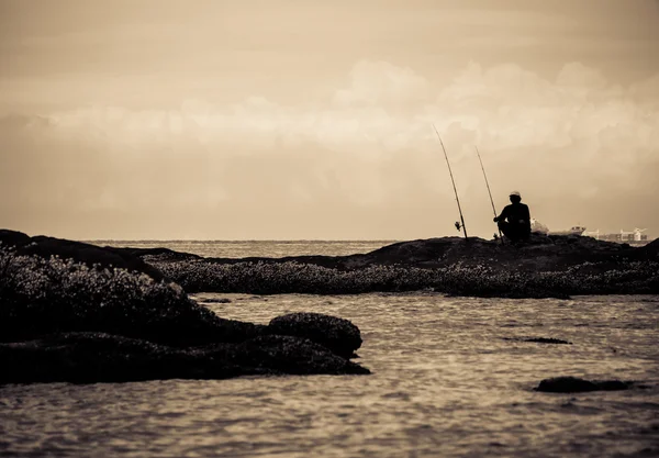 Silhouette de personnes pêchant au bord de la mer Image En Vente