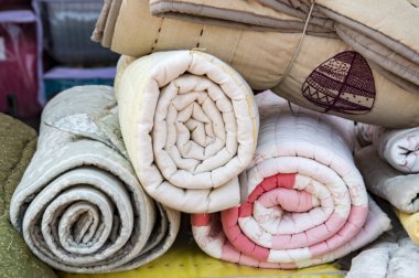 Rolled quilts on display and sale clipart