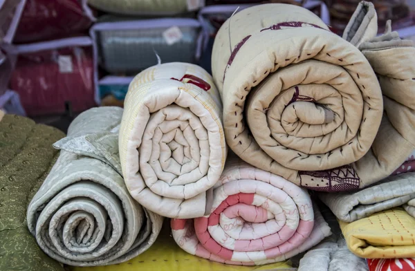 Haufen gerollte Steppdecken — Stockfoto