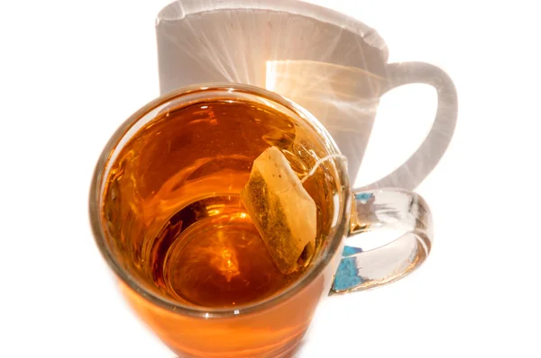 Copo tendo chá e saco de chá — Fotografia de Stock