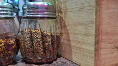 Oregano ve kırmızı biber baharatları şeffaf fıskiye şişelerinde ayrıntılı bir şekilde sergilenir..