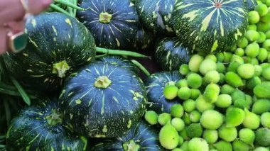 Bir dükkânda bir yığın balkabağı, fasulye ve diğer sebzeler satılığa çıkarılarak taze ürünler sunuluyor..