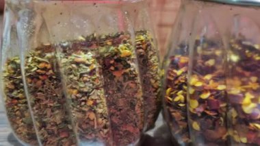 Pizza çeşnisi için bitkiler ve biber parçaları içeren iki fıskiye şişesi yandan ve üstten gösteriliyor.