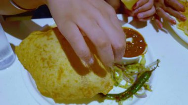 Bir kadın geleneksel bir Bhature yemeğinden zevk alır. Kolesistektomi ve kase ile servis edilir. Klasik tatları ön plana çıkarır..