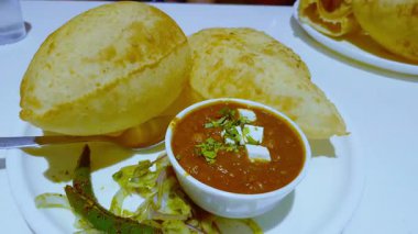 Soldan sağa tava, masada dinlenen kolesistektomi ve bhatürle dolu bir tabak yakalar..