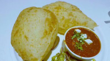 Tabakta kolesistektomi, iki bhature, peynir, soğan ve kırmızı biber var. Çeşitli lezzet kombinasyonları sunuyor..