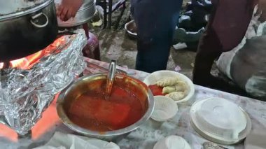 Bir adam Çin Momo 'sunu ya da hamur köftesini sıcak bir ocakta pişirir. Yeni hazırlanmış tabaktan buhar yükselir..