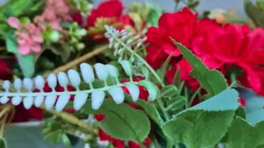 Yeşil saplı renkli sahte çiçekler, görsel çeşitliliği vurgulayan bir mağazada satılığa çıkarılır..