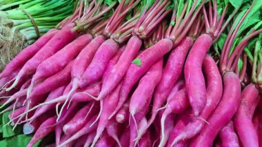 Bir dükkanda satılık kırmızı turplar sunuluyor. Parlak ten ve üniforma renkleri gösteriliyor..