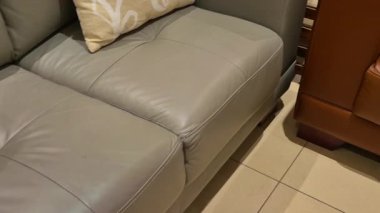 Ahşap kaplamalı ve tasarımcı detaylarıyla rahat bir kanepe sergilenmekte, zarif iç dekorasyon sunuluyor.