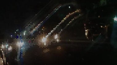 Bulanık altın ve mavi ışık kümeleri karanlık bir gece sahnesinde ritmik ve odak dışı bir bokeh etkisine sahiptir. Bu atmosferik vj döngüsü hızlı hareket eden bir şehrin enerjisini yakalar..