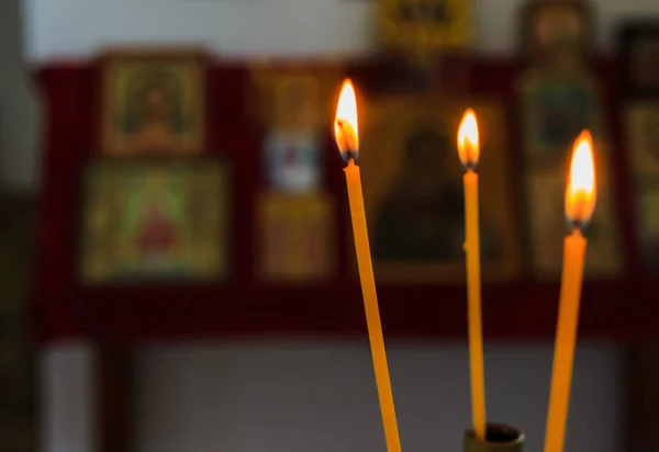 Three candles burning in small orthodox chapel, symbol of life and hope for Christians