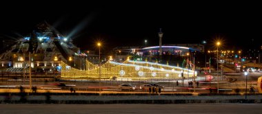 Kazan, Rusya - 07 Ocak 2021: Eğlence kompleksi Piramidi ve Spor Sarayı 'nın gece görüşü. Sokaklar yeni yıl için çelenklerle süslenmiştir..